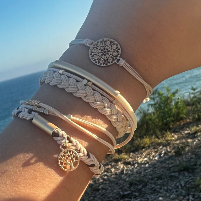 Close-up of a wrist wearing multiple bracelets with scenic background